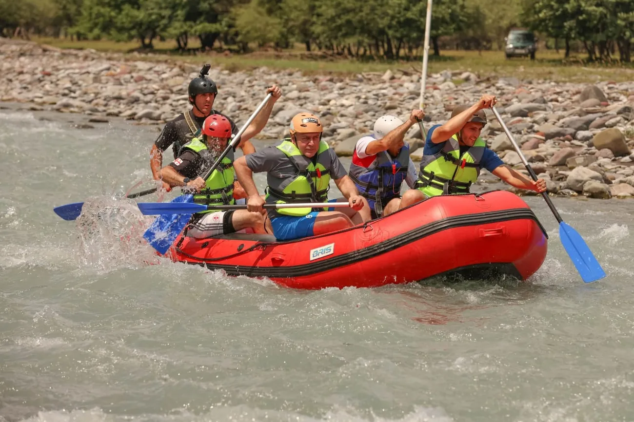 Crew paddling a red raft through a rapid on the Aragvi