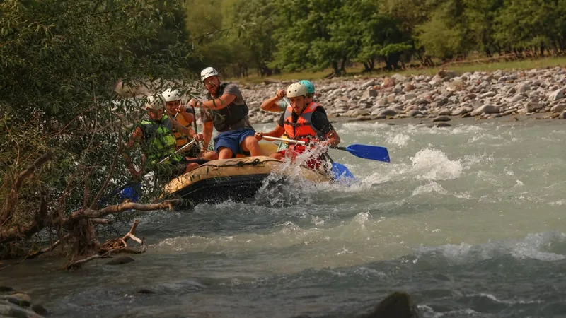 Rafting crew bracing through a rapid on the White Aragvi, paddles up and spray flying